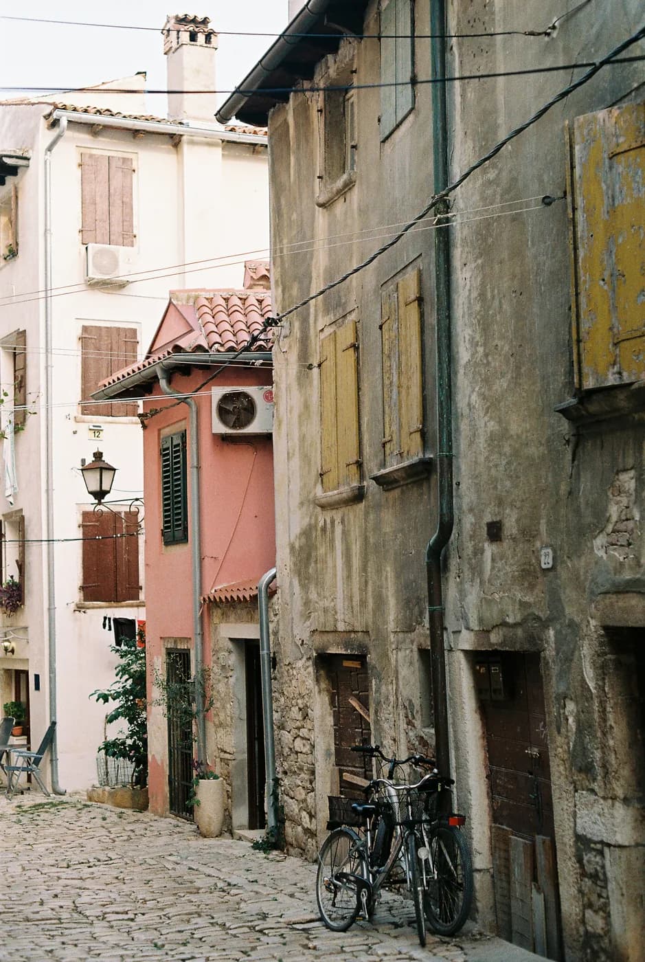 Bicycle beside weathered stone buildings on a cobbled street