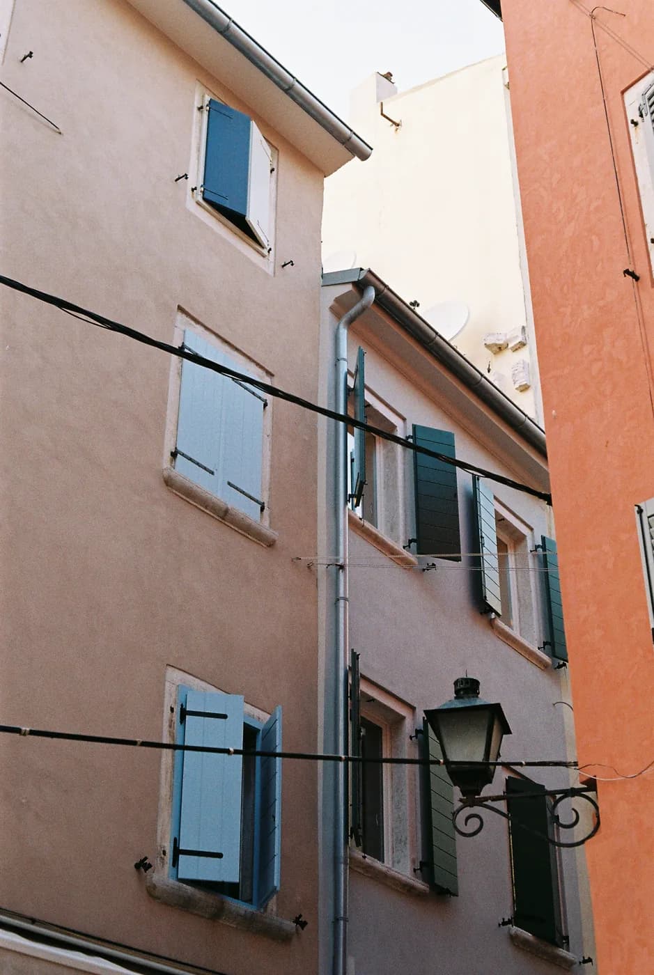 Pastel building facade with blue shutters