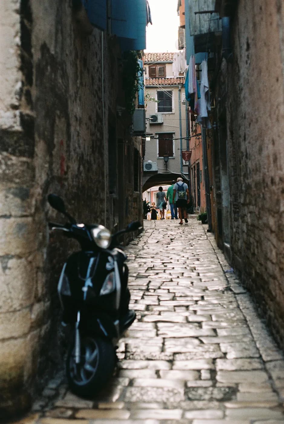 Dark scooter on a wet cobbled lane