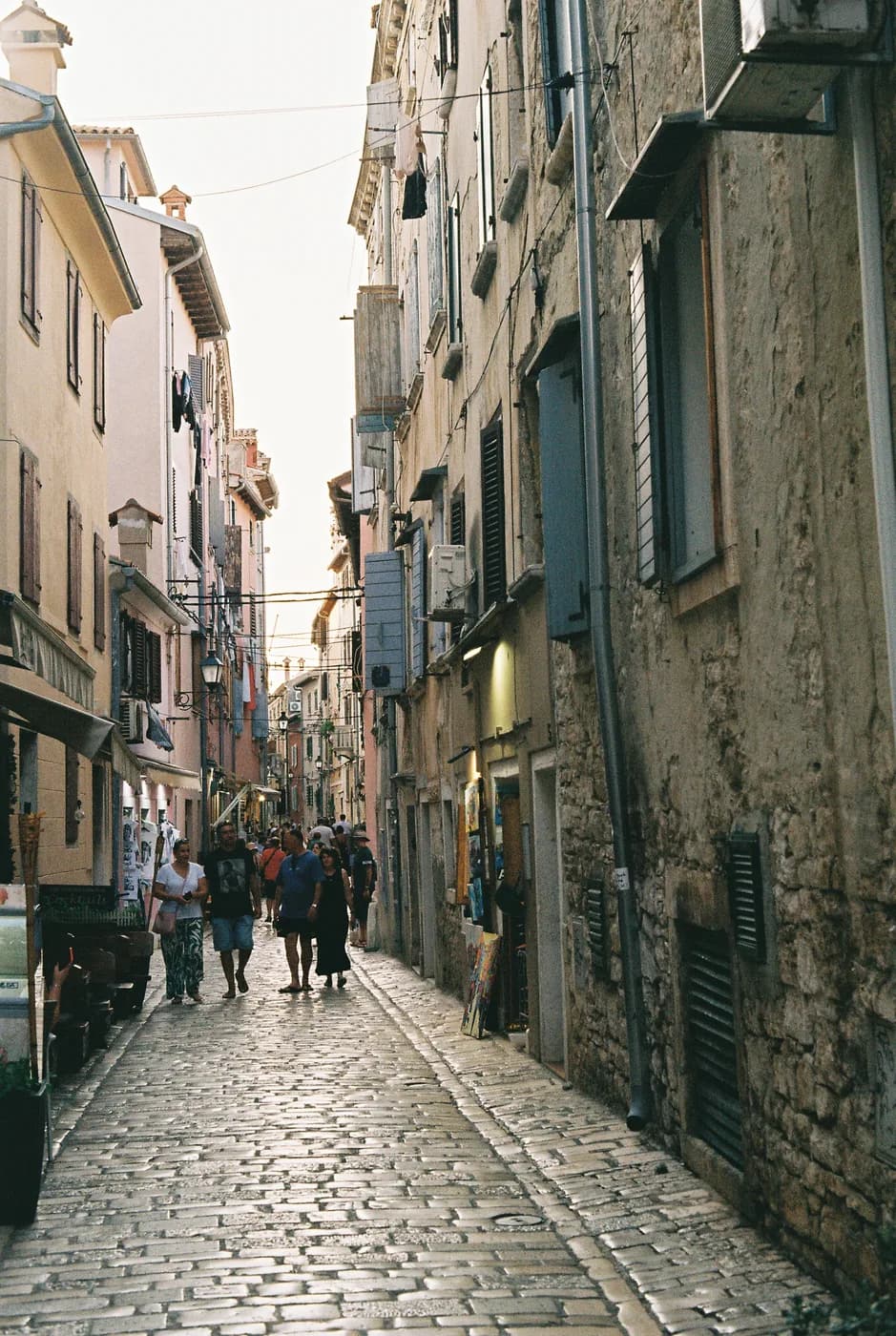 People walking along a narrow cobbled street