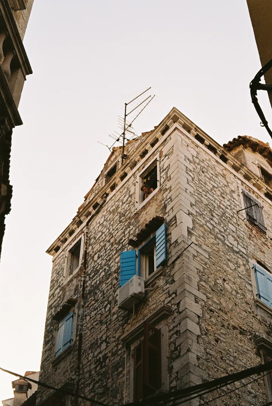 Upward view of an old stone building and pale sky