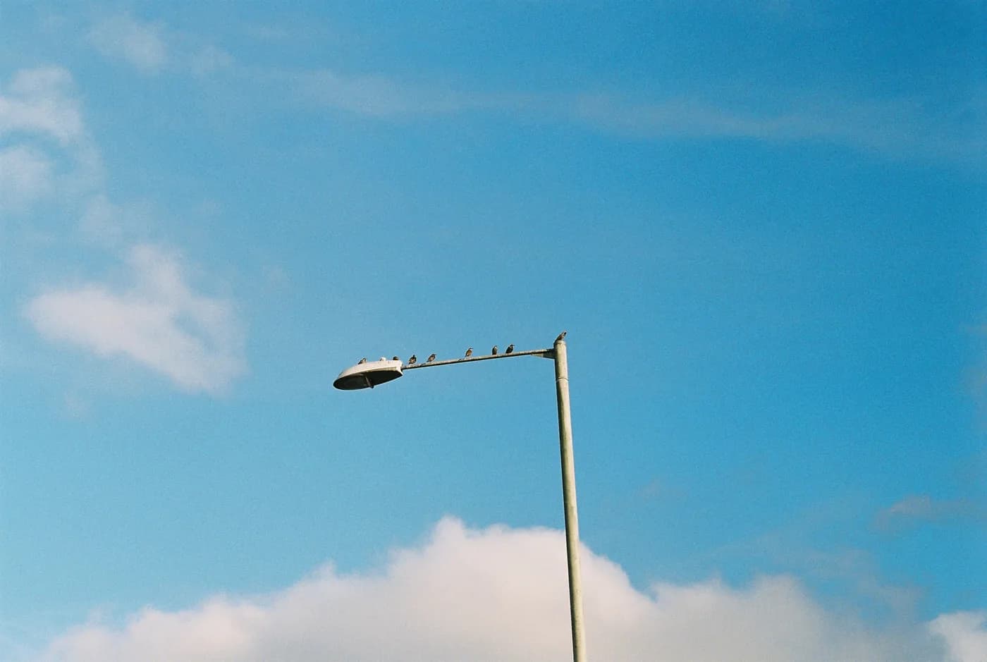 Streetlamp against a clear blue sky and soft clouds